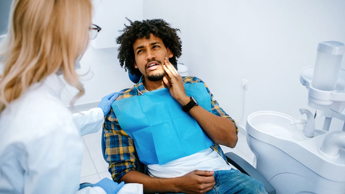 man in pain in dentist chair